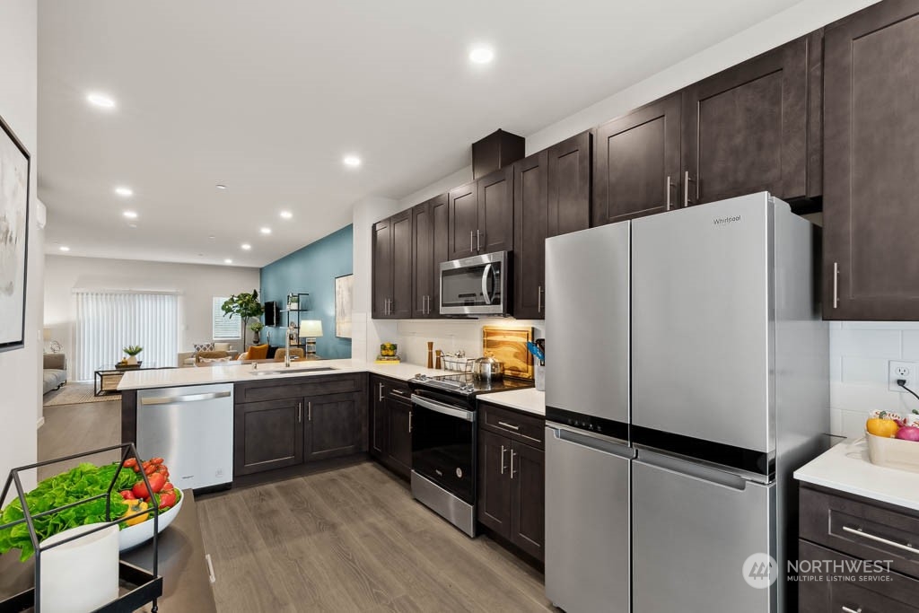 23413 Edmonds Way, Unit E2 Edmonds, WA 98026 - Photo 9 of 22 a kitchen with stainless steel appliances a refrigerator sink and microwave