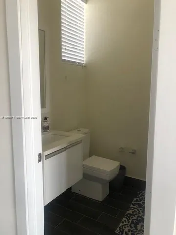 a white toilet sitting next to a bathroom sink