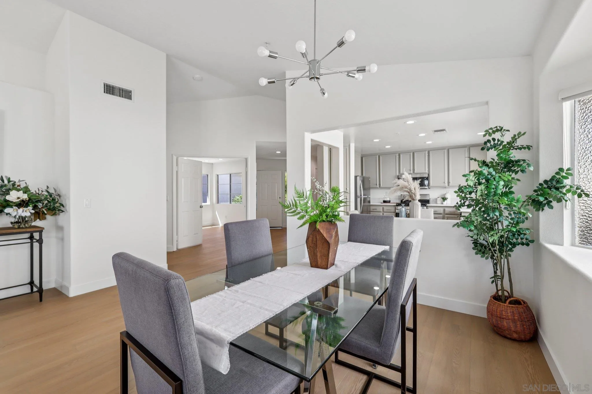 2491 Moonlight Glen Escondido, CA 92026 - Photo 11 of 58 a dining room with furniture potted plants and wooden floor
