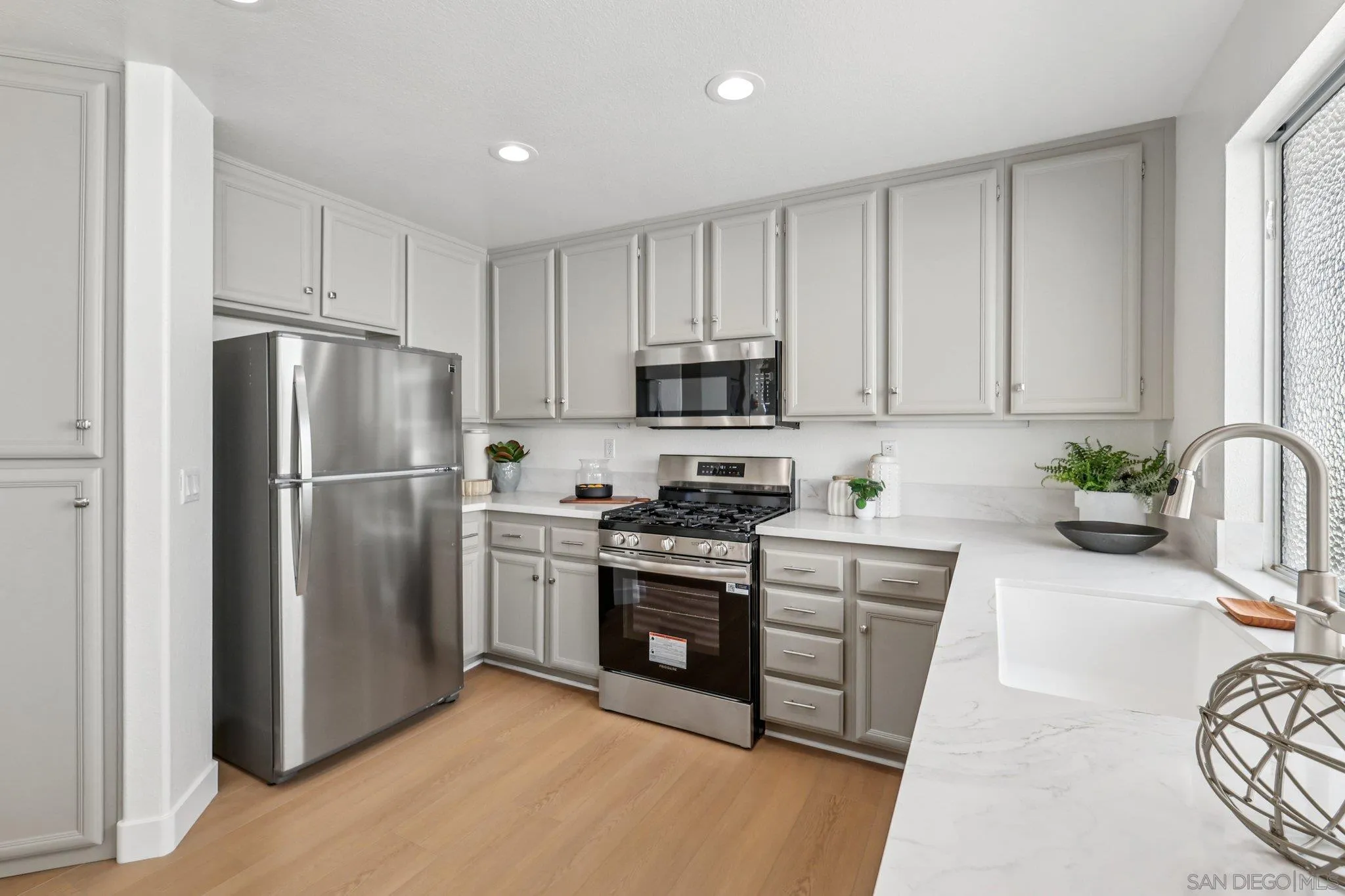 2491 Moonlight Glen Escondido, CA 92026 - Photo 16 of 58 a kitchen with stainless steel appliances granite countertop a refrigerator a stove a sink and white cabinets