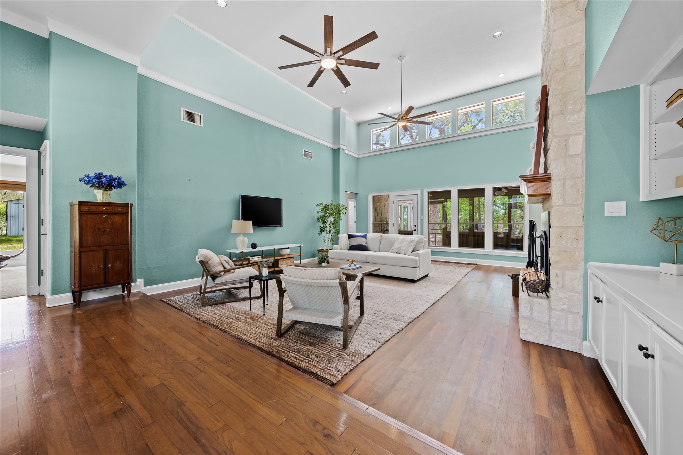 7670 Nez Perce Trace Manor, TX 78653 - Photo 6 of 40 Living room with visible vents, ceiling fan, a high ceiling, and dark wood finished floors