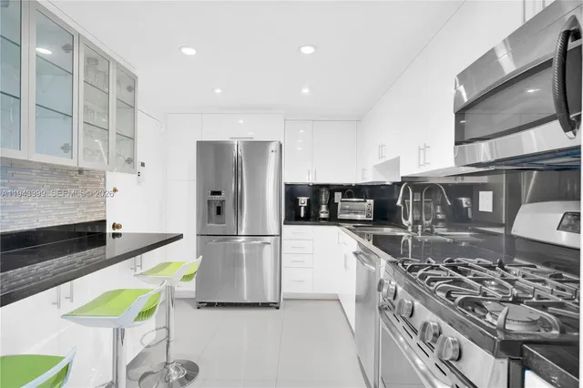 a dining room with wooden floor a chandelier a wooden table and chairs