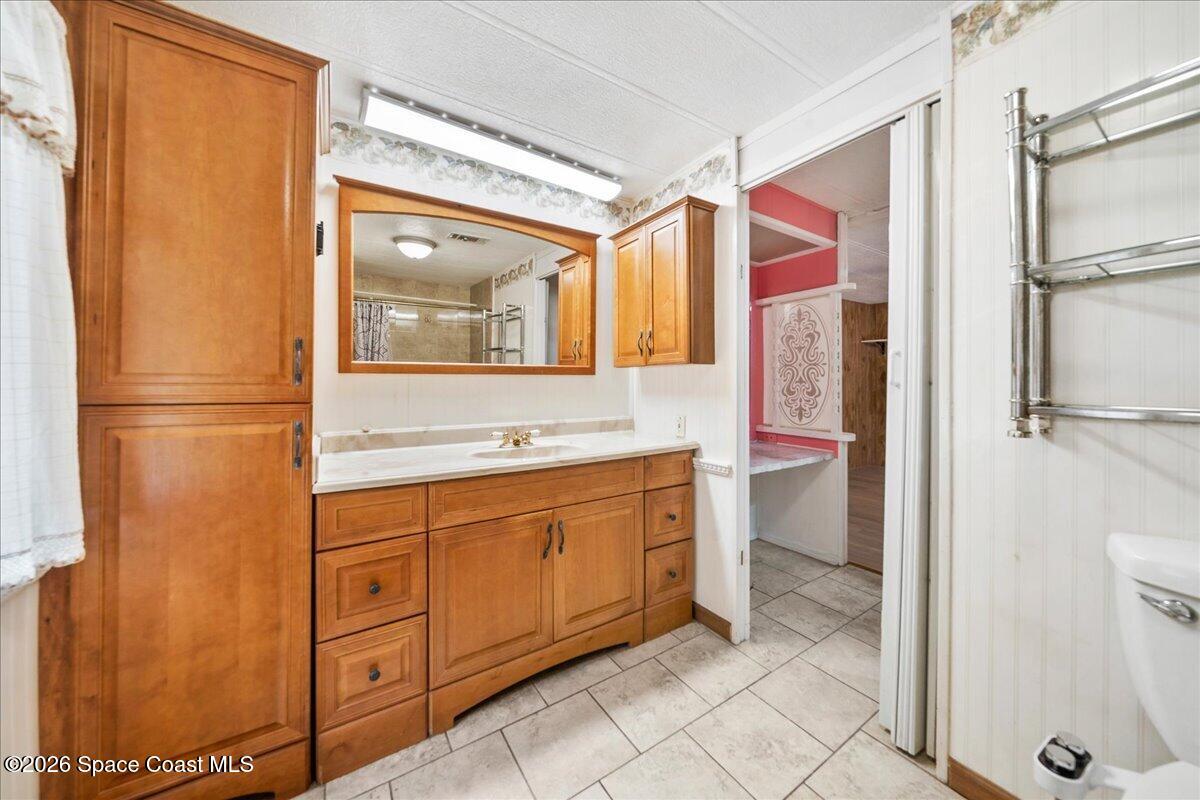 1813 Coco Plum Street Northeast Palm Bay, FL 32905 - Photo 12 of 44 a bathroom with a sink mirror and a shower