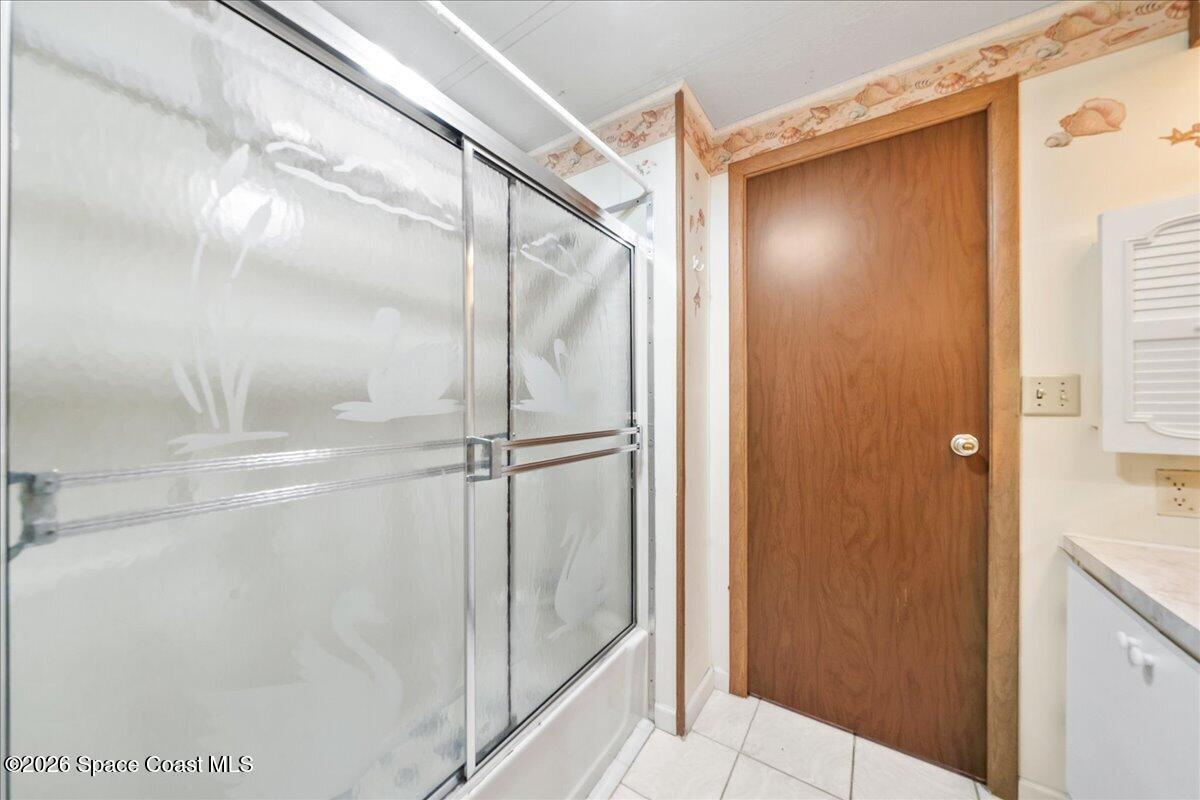 1813 Coco Plum Street Northeast Palm Bay, FL 32905 - Photo 17 of 44 a bathroom with a glass shower door