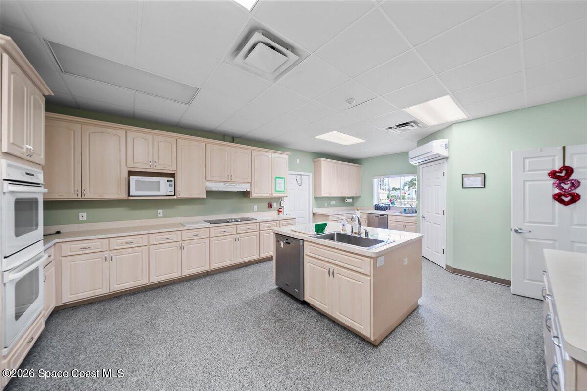 1813 Coco Plum Street Northeast Palm Bay, FL 32905 - Photo 40 of 44 a kitchen with kitchen island granite countertop a sink and cabinets