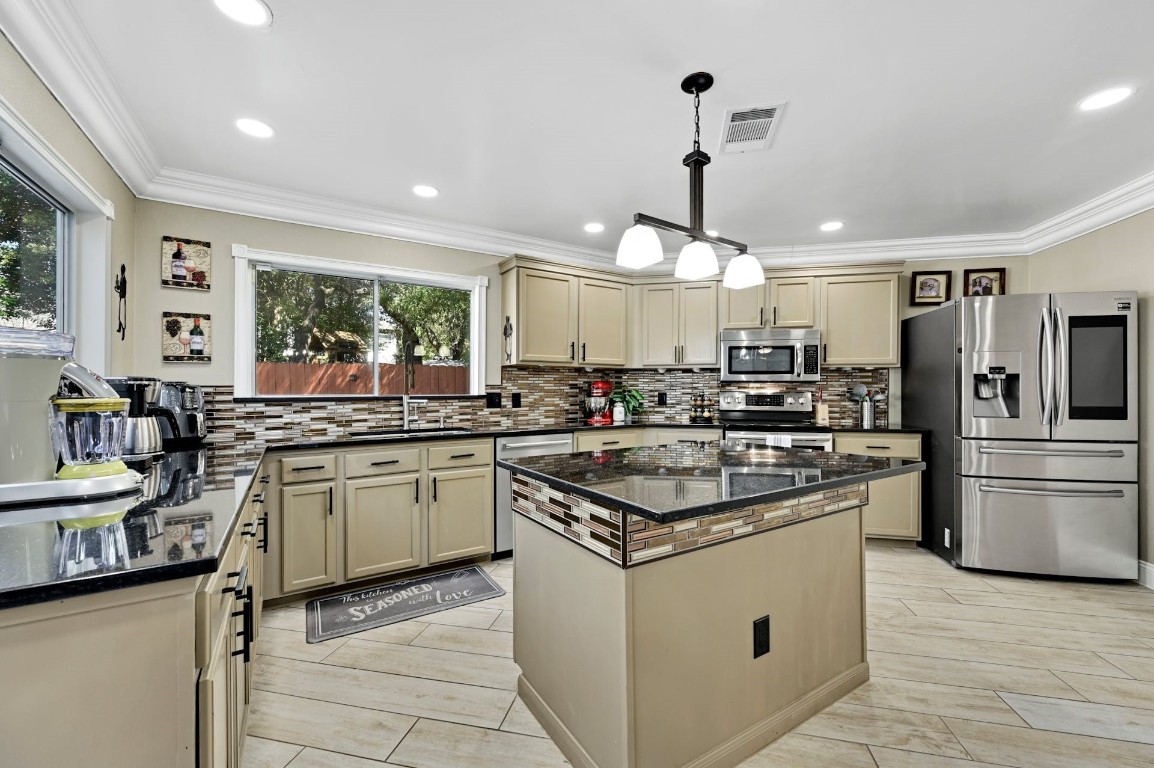 a kitchen with stainless steel appliances granite countertop a sink and stove