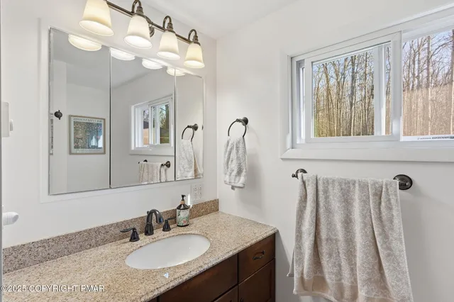a bathroom with a granite countertop sink and a mirror