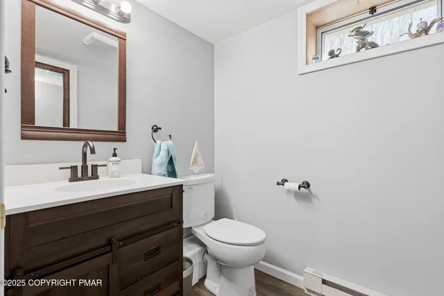 a bathroom with a sink vanity mirror and toilet