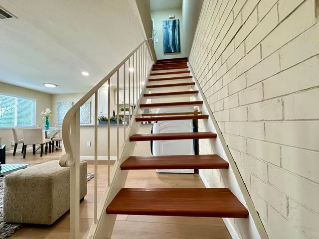 a view of staircase with lots of frames on wall and windows