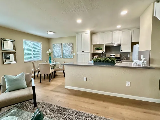 a view of kitchen with kitchen island microwave and cabinets