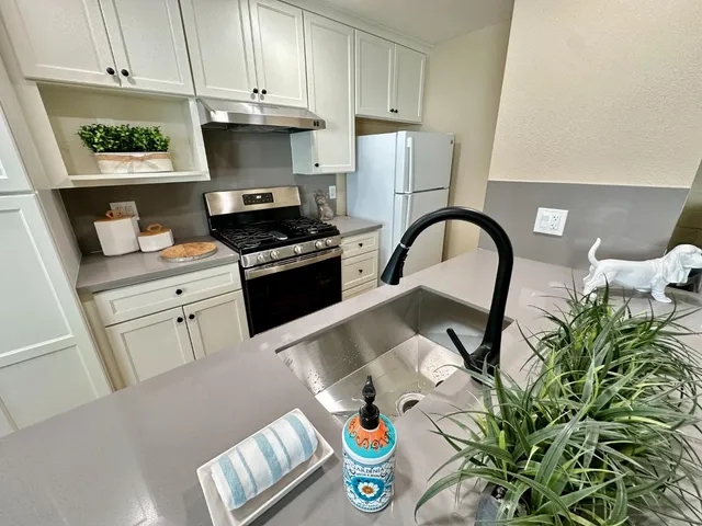 a kitchen with stainless steel appliances a stove a sink and a refrigerator