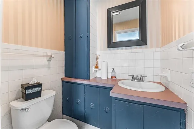 a bathroom with a toilet sink and mirror