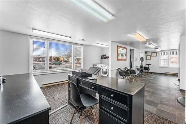 a dining hall with stainless steel appliances granite countertop a sink dishwasher and a black countertops with wooden floor