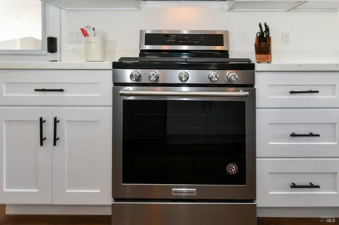 a stove top oven sitting inside of a kitchen