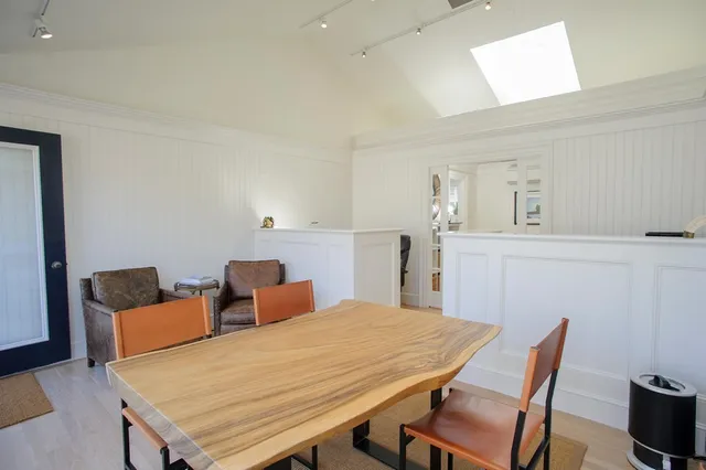 a room with a table chairs and wooden floor