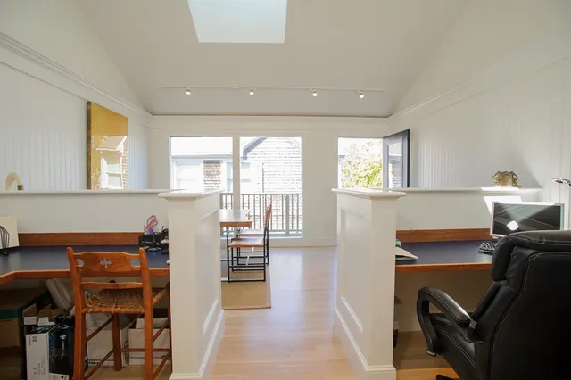 a view of a workspace with furniture and a window