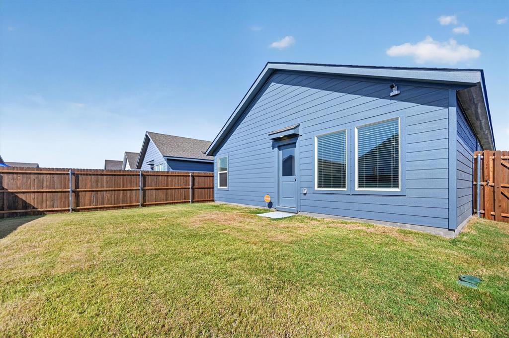1260 Balsam Road Wilmer, TX 75172 - Photo 18 of 20 Expansive grassy yard with a wood privacy fence and a blue siding exterior