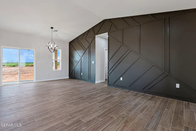 a view of a livingroom with wooden floor and a ceiling fan