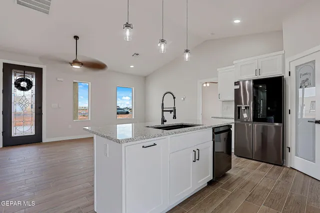 a kitchen with stainless steel appliances kitchen island a sink and a refrigerator