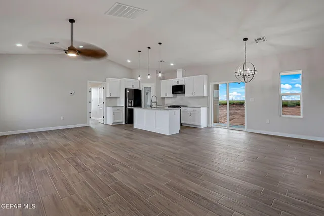 a view of a kitchen with stainless steel appliances refrigerator stove microwave and cabinets