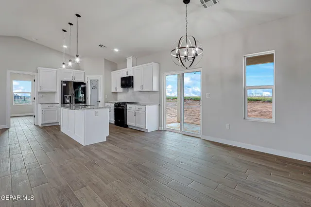 a view of a kitchen with granite countertop stainless steel appliances and wooden floor
