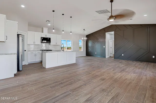 a view of kitchen with stainless steel appliances kitchen island a refrigerator and a stove top oven