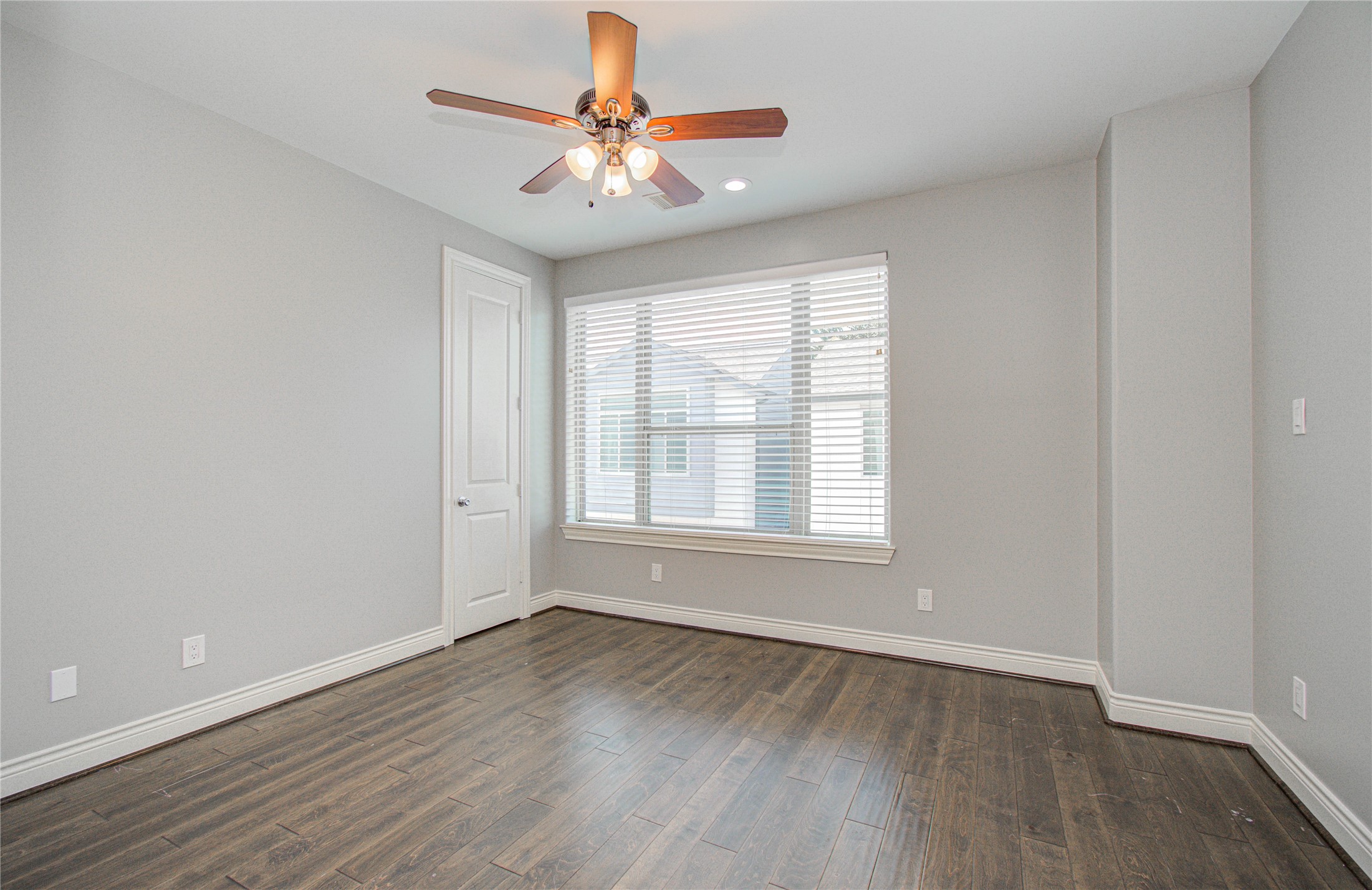 8903 Spring Knoll Forest Drive Houston, TX 77080 - Photo 16 of 29 an empty room with wooden floor chandelier fan and windows