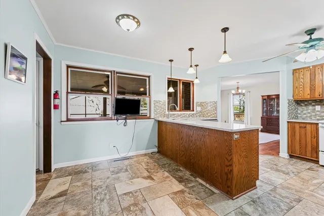 a view of a kitchen with kitchen island granite countertop a refrigerator and a sink
