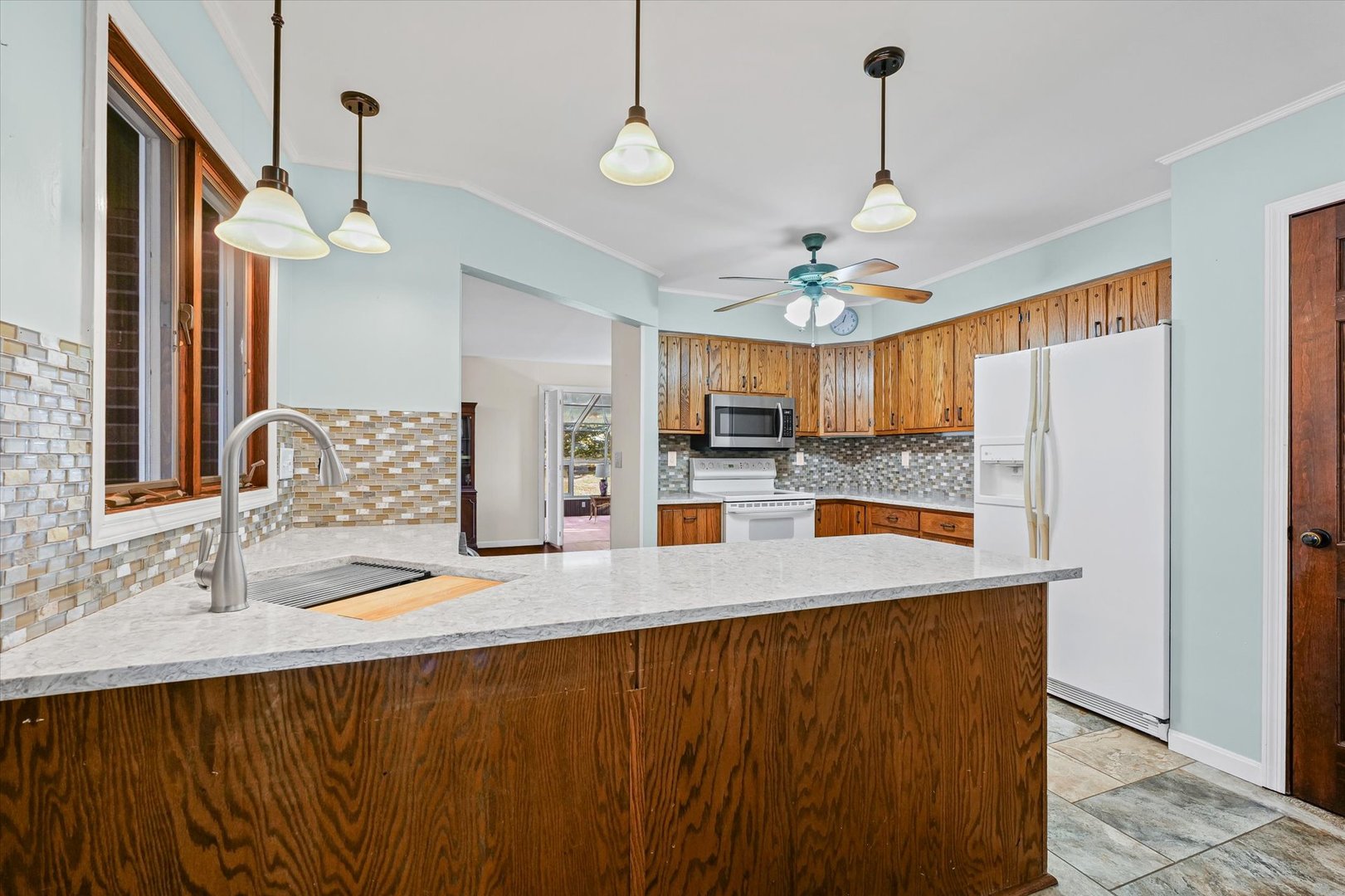 1000 East Kratz Road Monticello, IL 61856 - Photo 15 of 52 a kitchen with stainless steel appliances granite countertop a refrigerator a sink dishwasher a stove and a dining table with wooden floor