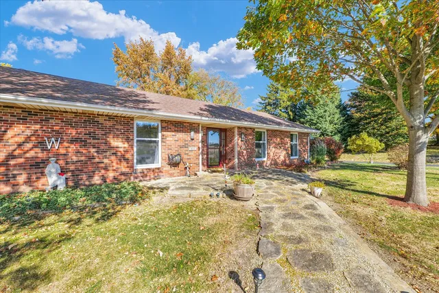 a view of a house with backyard and sitting area