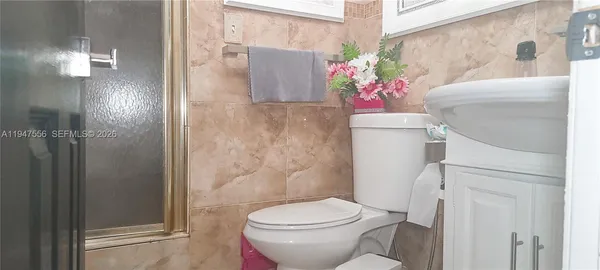 a white toilet sitting next to a bathroom
