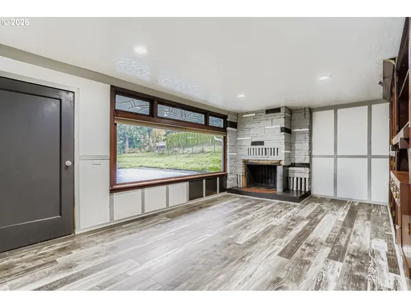 a view of empty room with wooden floor and fireplace