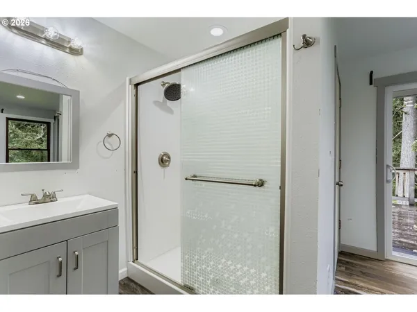 a bathroom with a shower sink and mirror