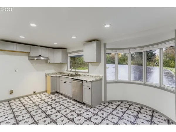 a kitchen with granite countertop a stove a sink and a refrigerator