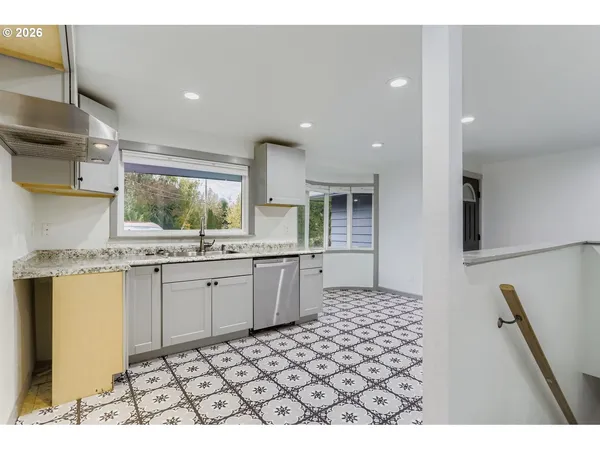a kitchen with granite countertop a sink and a stove top oven