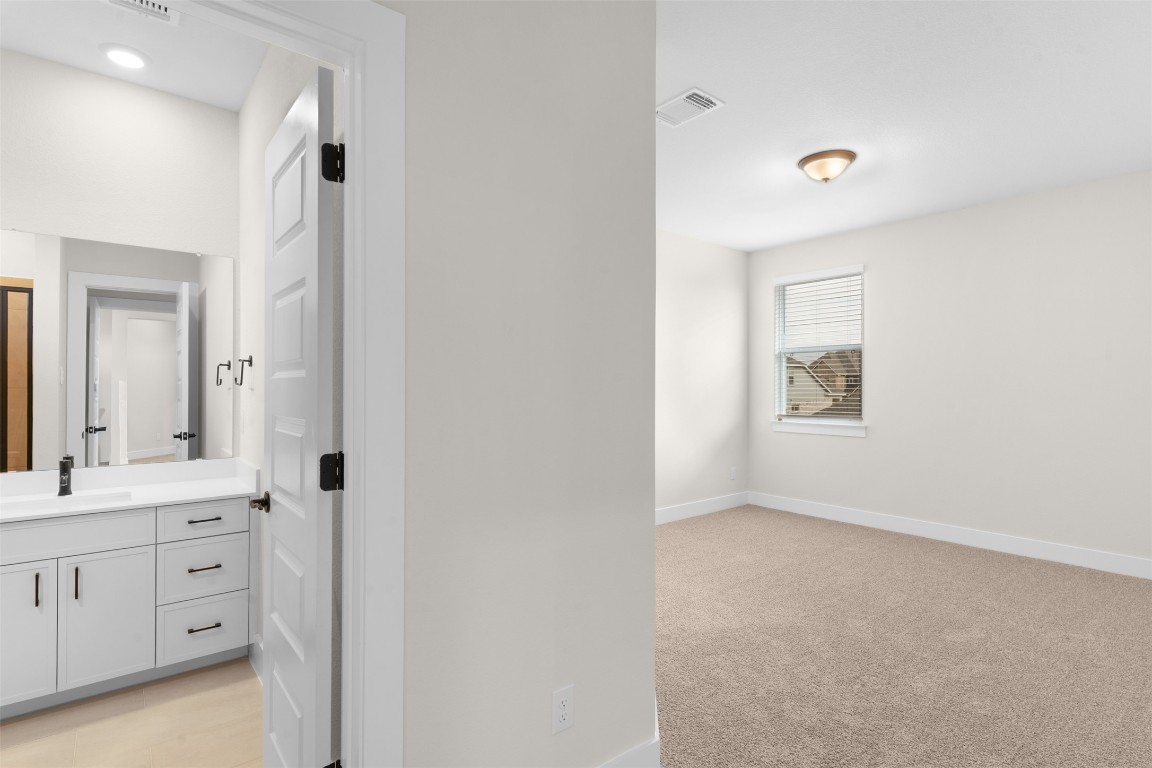 19513 Domino Champ Road Pflugerville, TX 78660 - Photo 18 of 28 a view of bathroom with two mirror and a sink
