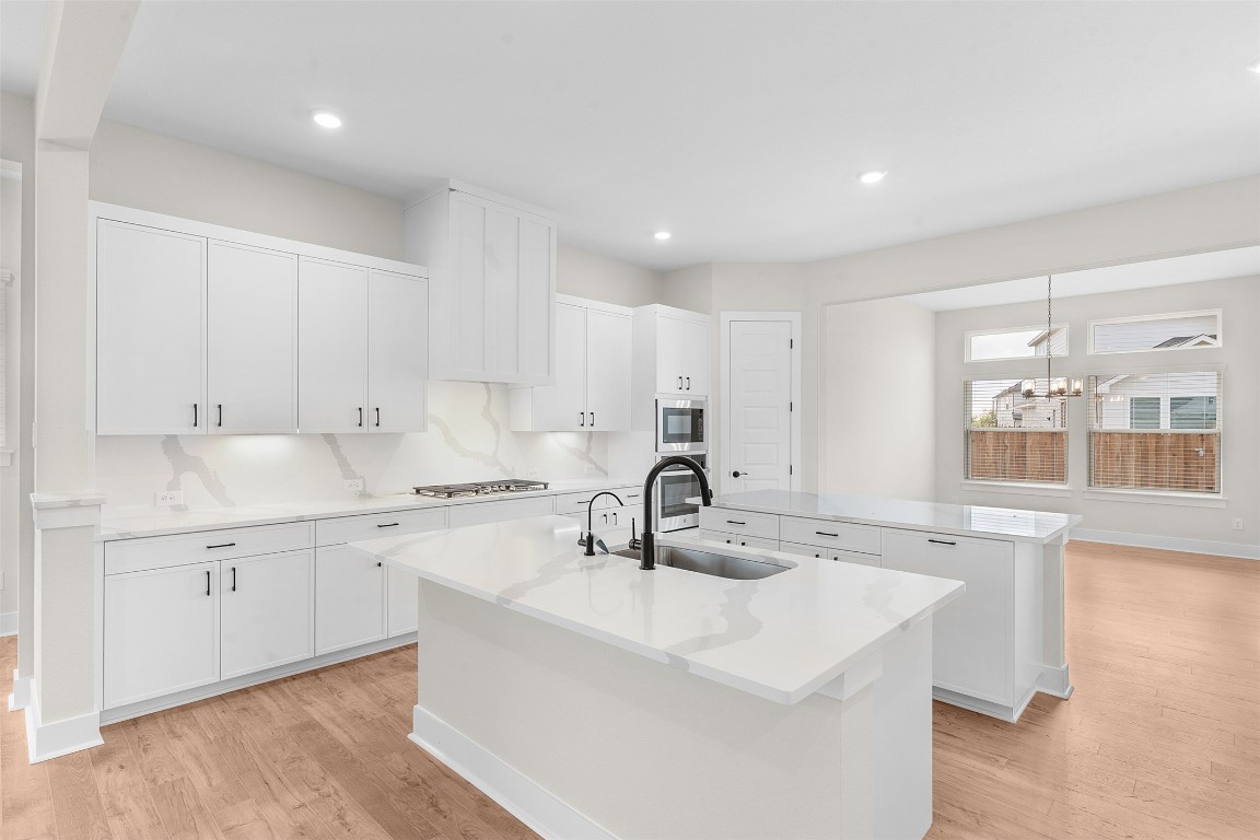 19513 Domino Champ Road Pflugerville, TX 78660 - Photo 8 of 28 a kitchen with granite countertop a sink and cabinets