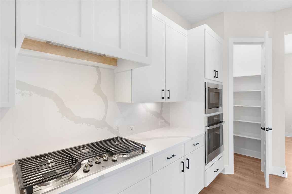 19513 Domino Champ Road Pflugerville, TX 78660 - Photo 9 of 28 a kitchen with white cabinets and appliances