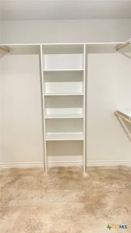 a view of walk in closet with empty racks