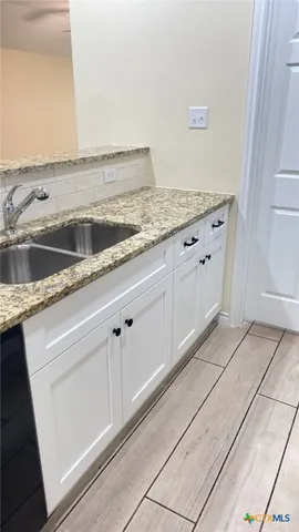 a view white cabinets and a sink