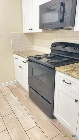 a kitchen with granite countertop a sink and a stove