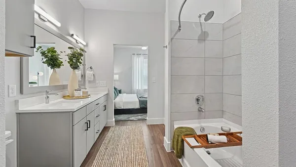 a bathroom with a tub sink and mirror