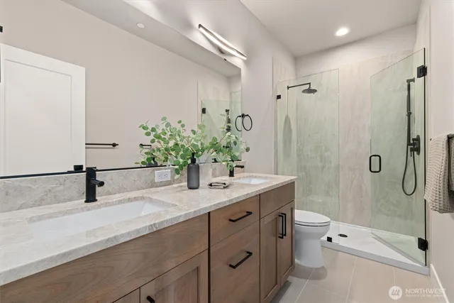 a bathroom with a granite countertop sink a toilet and shower