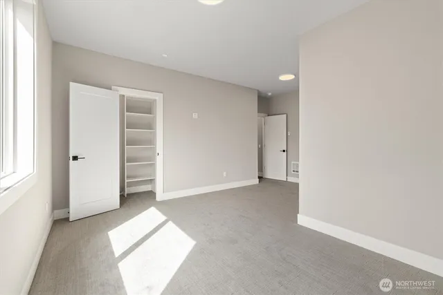 an empty room with windows and closet