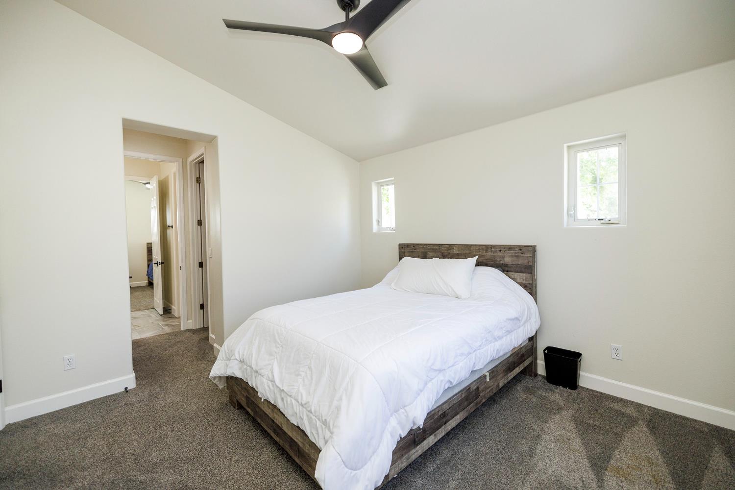1682 Fairway Oaks Court Ripon, CA 95366 - Photo 34 of 51 a large bed sitting in a bedroom next to a window and a chandelier