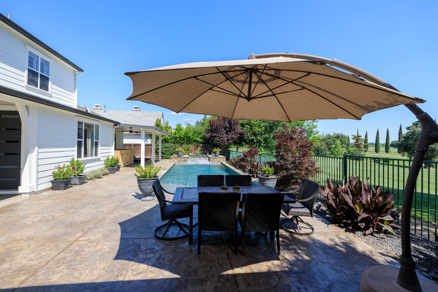 1682 Fairway Oaks Court Ripon, CA 95366 - Photo 38 of 51 a patio with a table and chairs under an umbrella