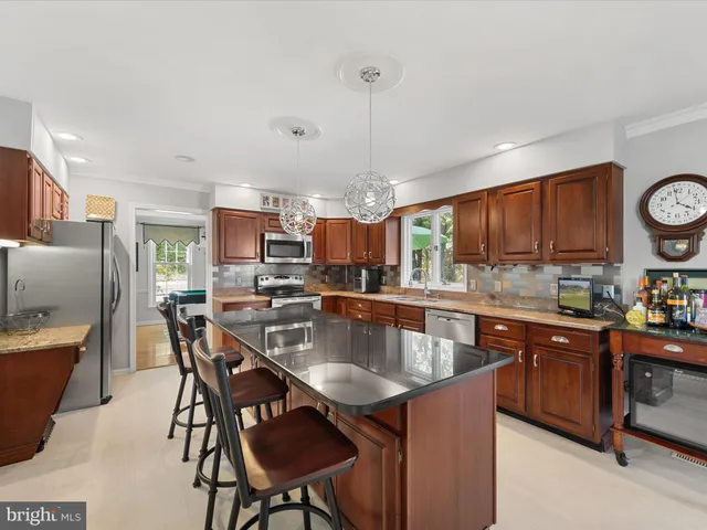 a kitchen with granite countertop a table chairs sink and cabinets