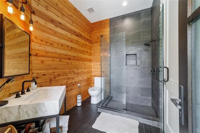a bedroom with a bed a chandelier and flat screen tv