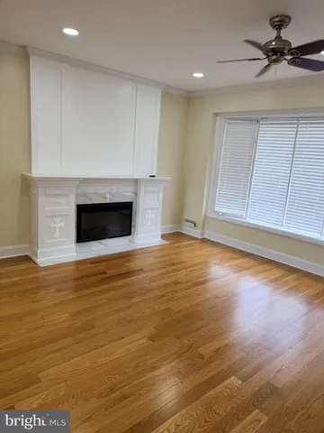 a view of empty room with wooden floor and fireplace
