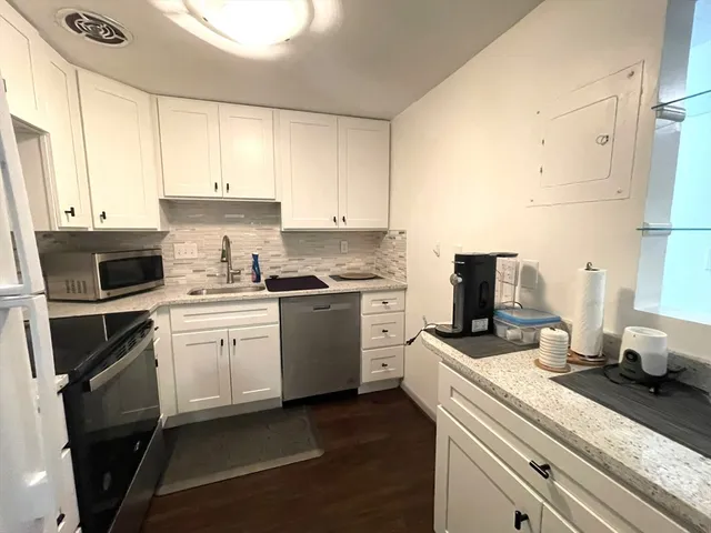 a kitchen with a sink stove and white cabinets